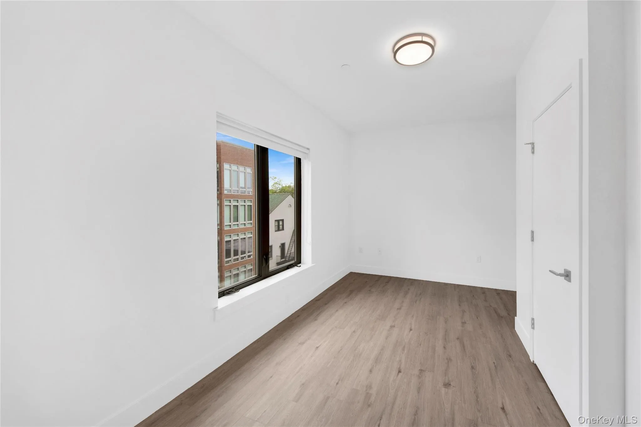 Spare room featuring wood finished floors and baseboards Spare room featuring wood finished floors and baseboards