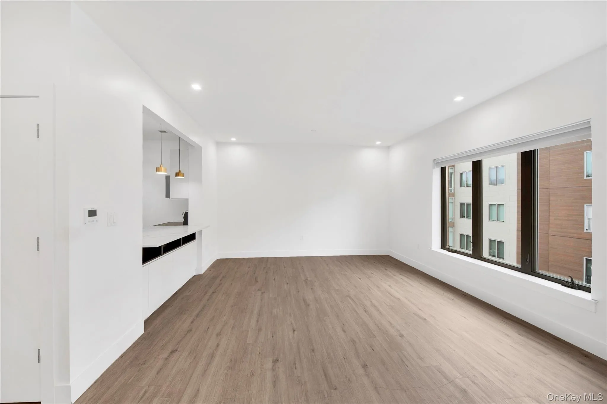 Unfurnished living room with light wood-style flooring and recessed lighting Unfurnished living room with light wood-style flooring and recessed lighting