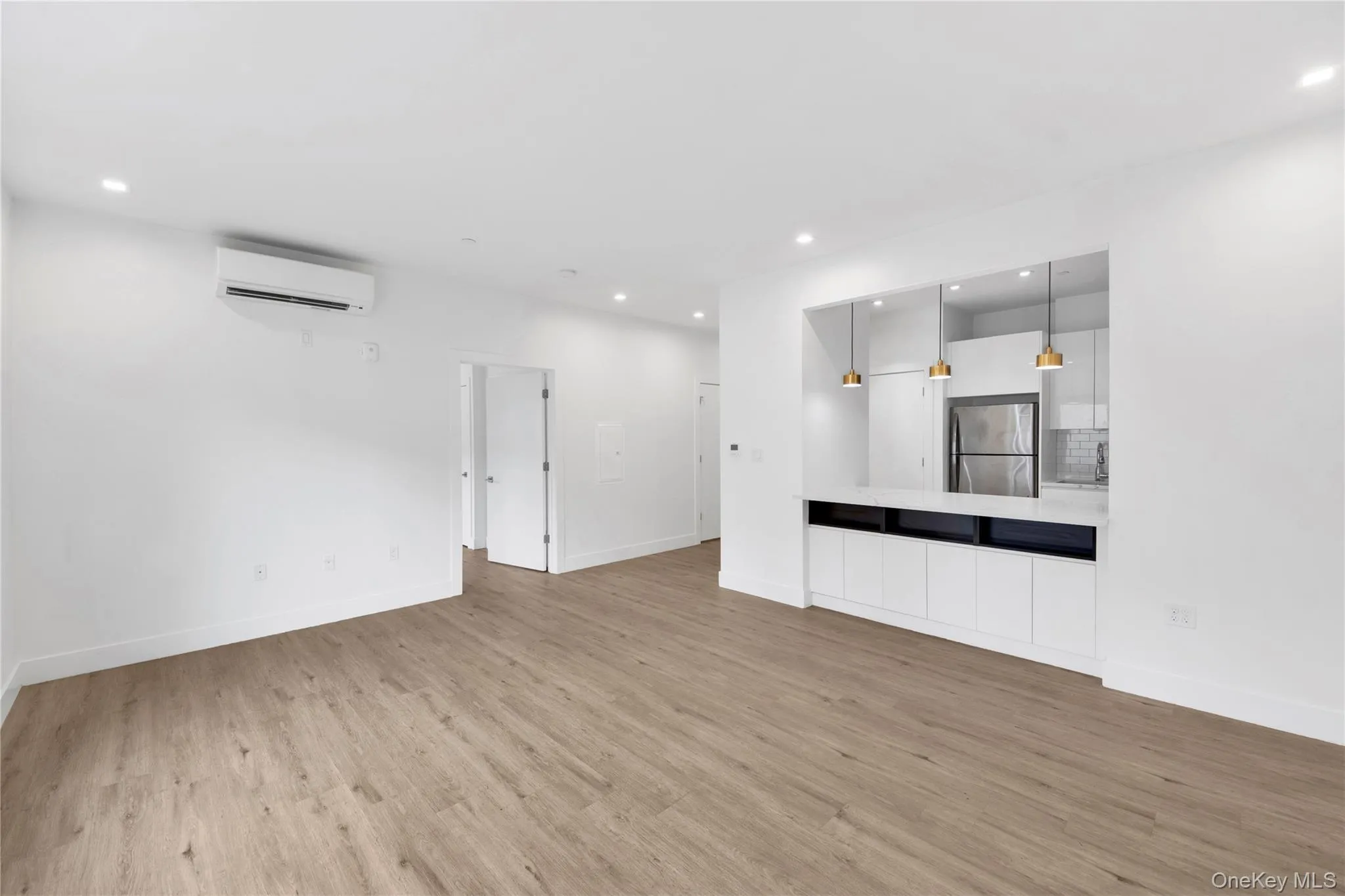 Unfurnished living room with recessed lighting, light wood-style floors, and a wall mounted AC Unfurnished living room with recessed lighting, light wood-style floors, and a wall mounted AC