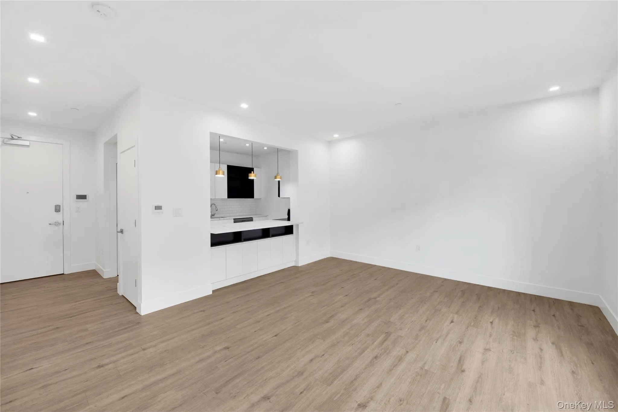 Empty room with light wood-style floors and recessed lighting Empty room with light wood-style floors and recessed lighting