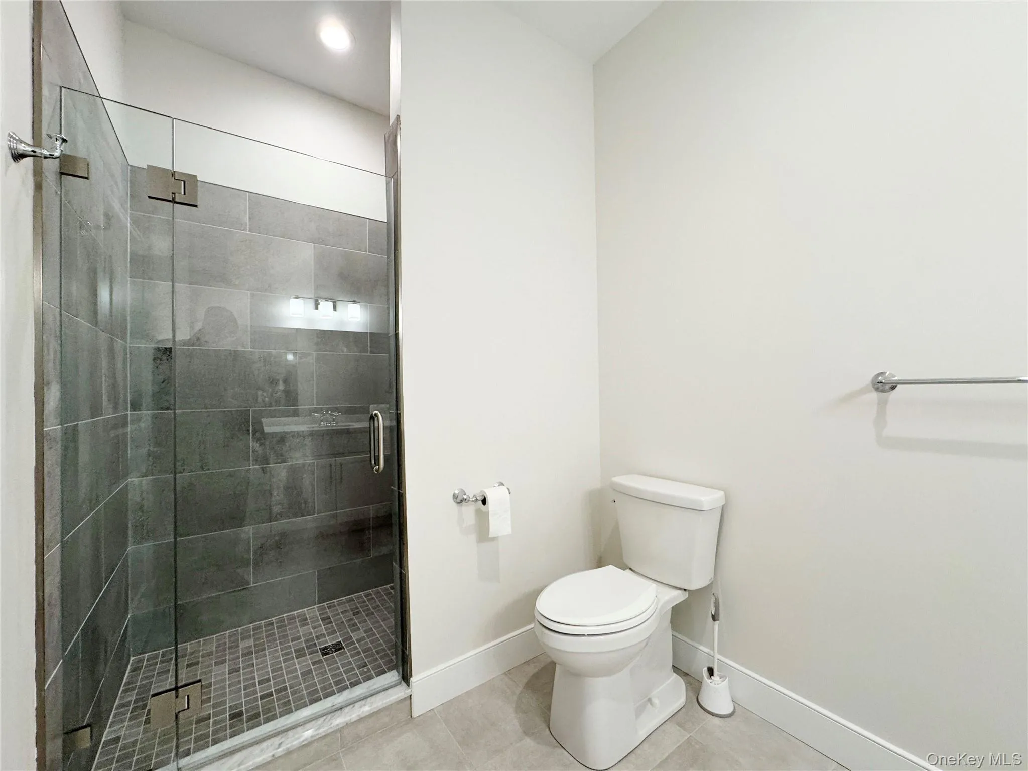 Full bathroom with a shower stall and light tile patterned floors Full bathroom with a shower stall and light tile patterned floors