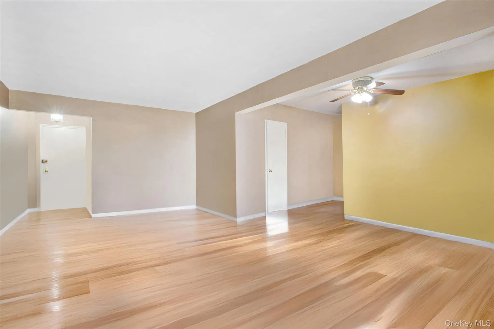 Spare room with light wood-style floors and a ceiling fan Spare room with light wood-style floors and a ceiling fan