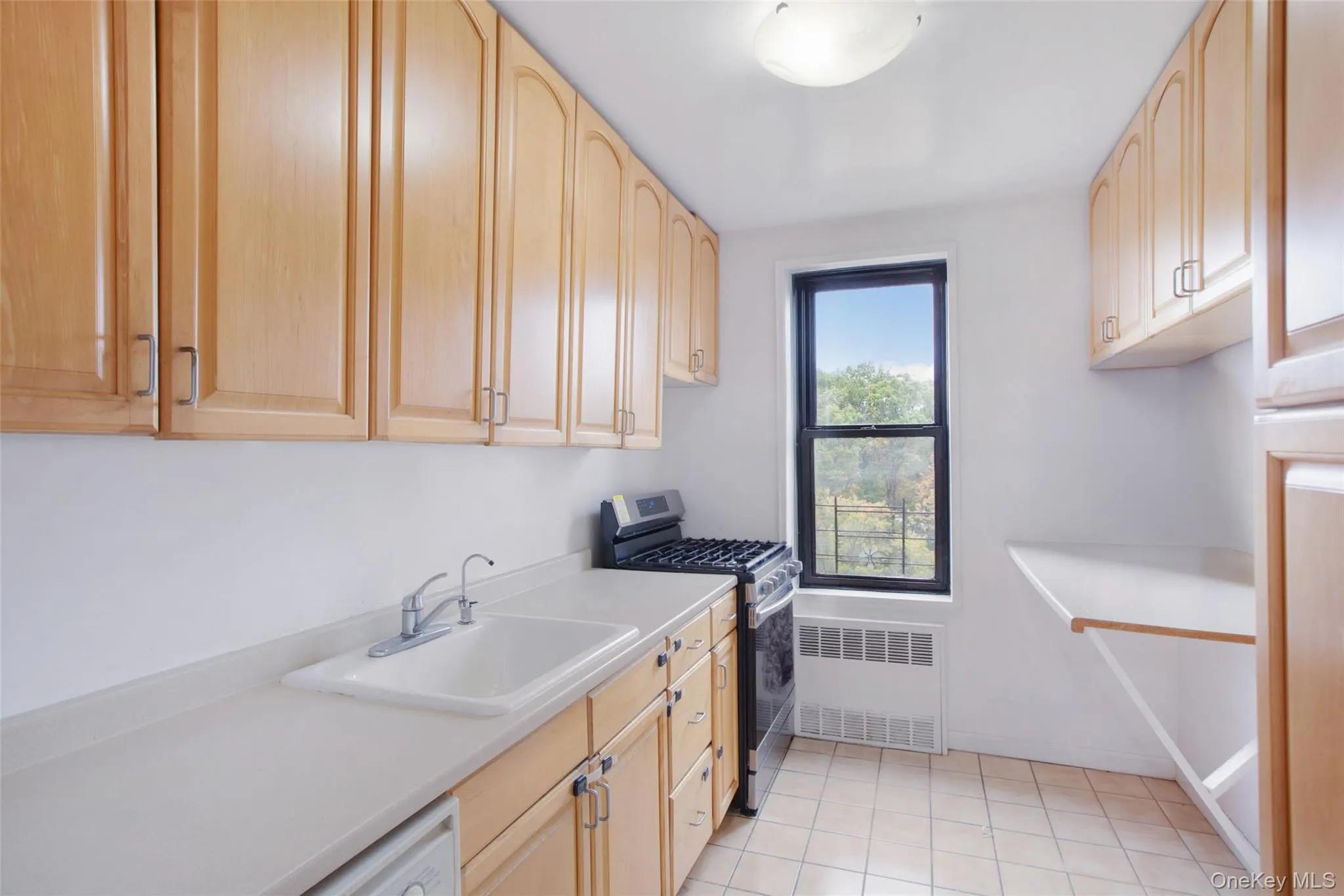 Laundry room featuring light tile patterned floors and radiator heating unit Laundry room featuring light tile patterned floors and radiator heating unit