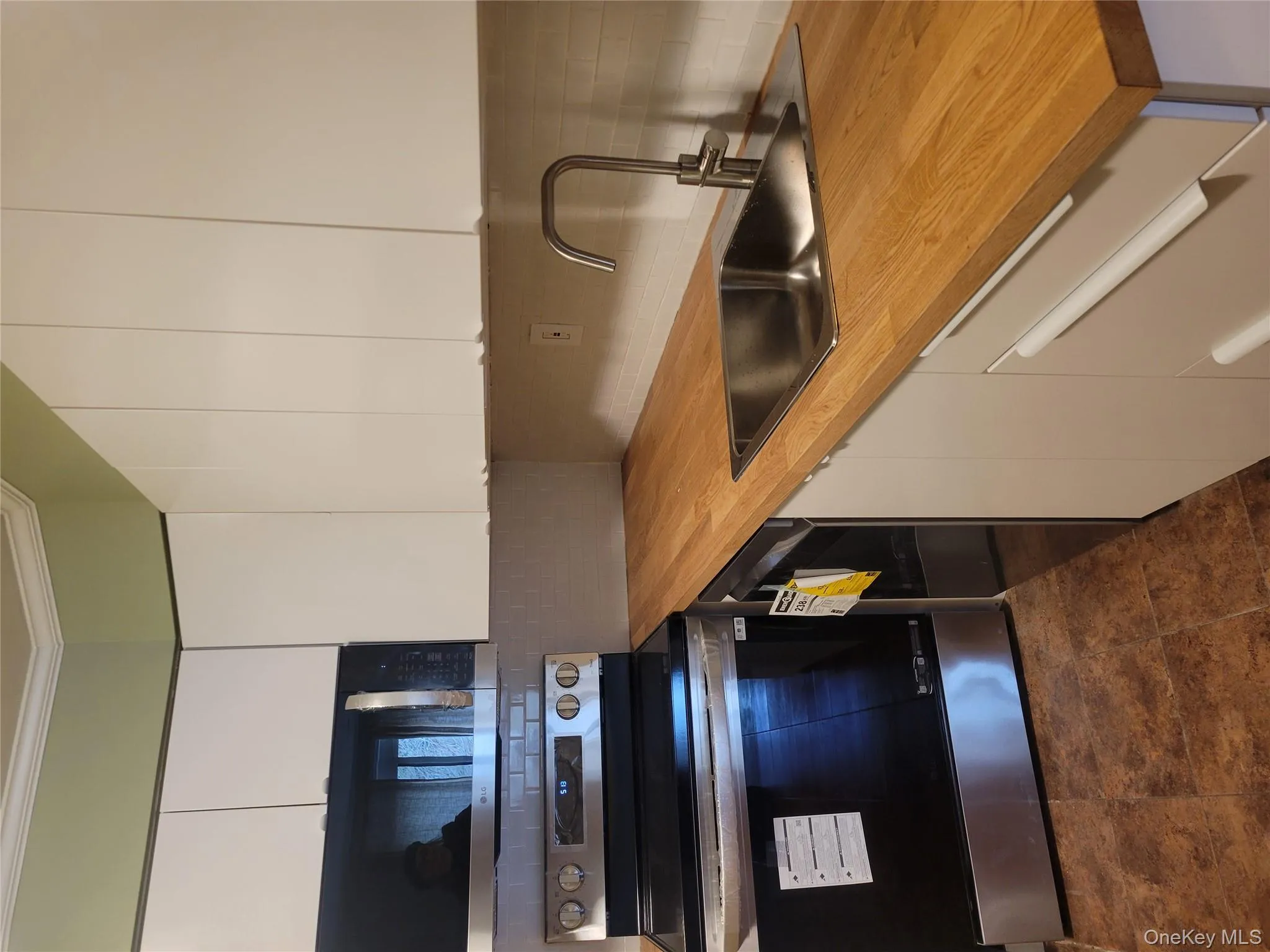 Kitchen featuring range, white cabinets, decorative backsplash, dishwasher, and crown molding Kitchen featuring range, white cabinets, decorative backsplash, dishwasher, and crown molding