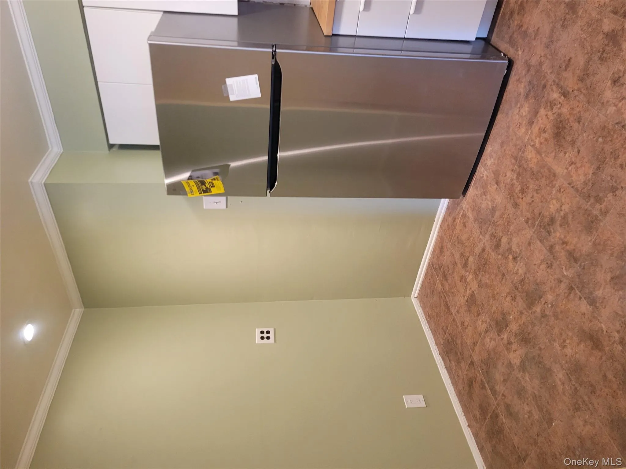 Kitchen featuring stainless steel refrigerator, white cabinets, ornamental molding, dark flooring, and recessed lighting Kitchen featuring stainless steel refrigerator, white cabinets, ornamental molding, dark flooring, and recessed lighting