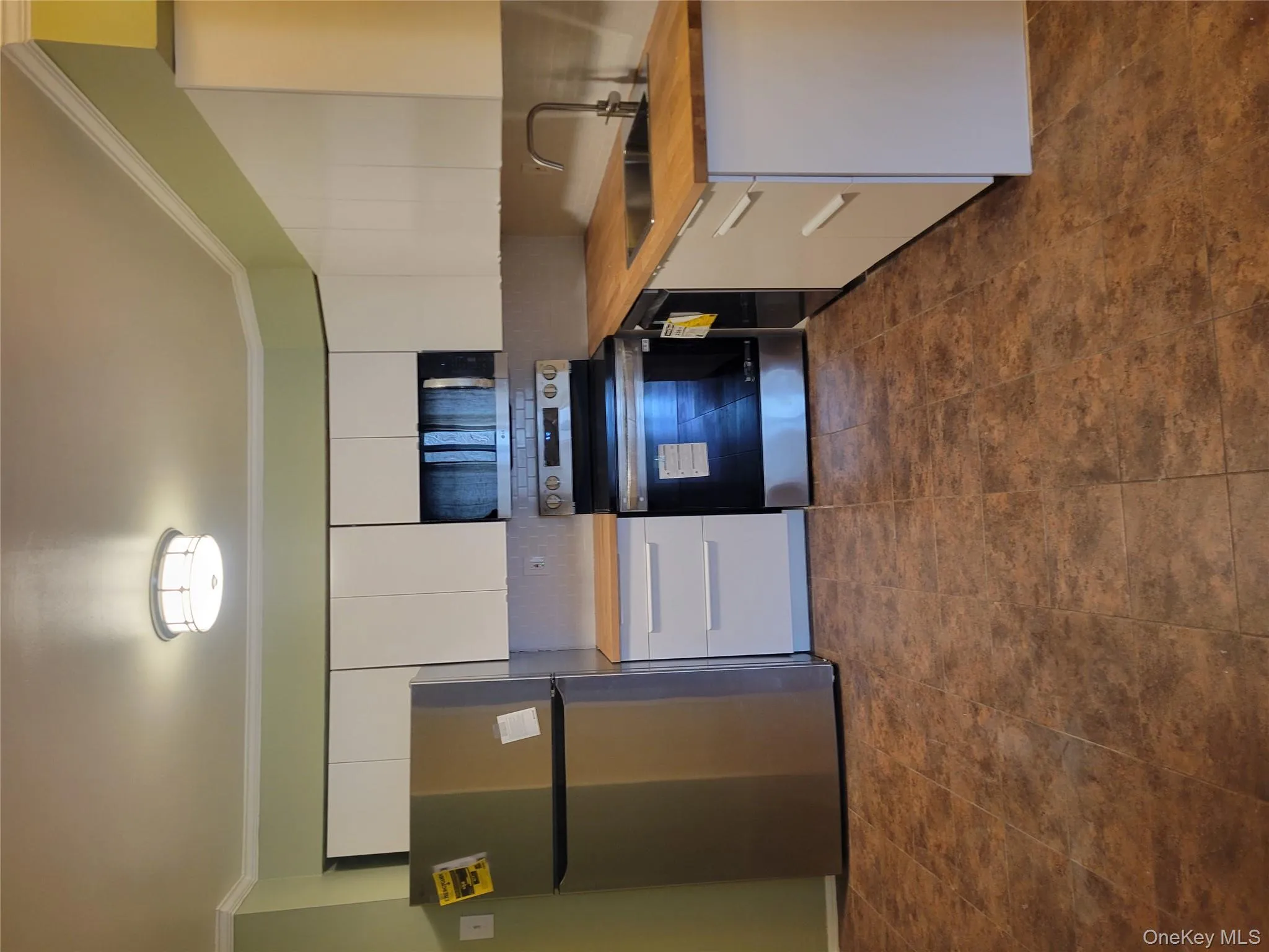 Kitchen with stainless steel appliances, white cabinets, crown molding, backsplash, and butcher block countertops Kitchen with stainless steel appliances, white cabinets, crown molding, backsplash, and butcher block countertops