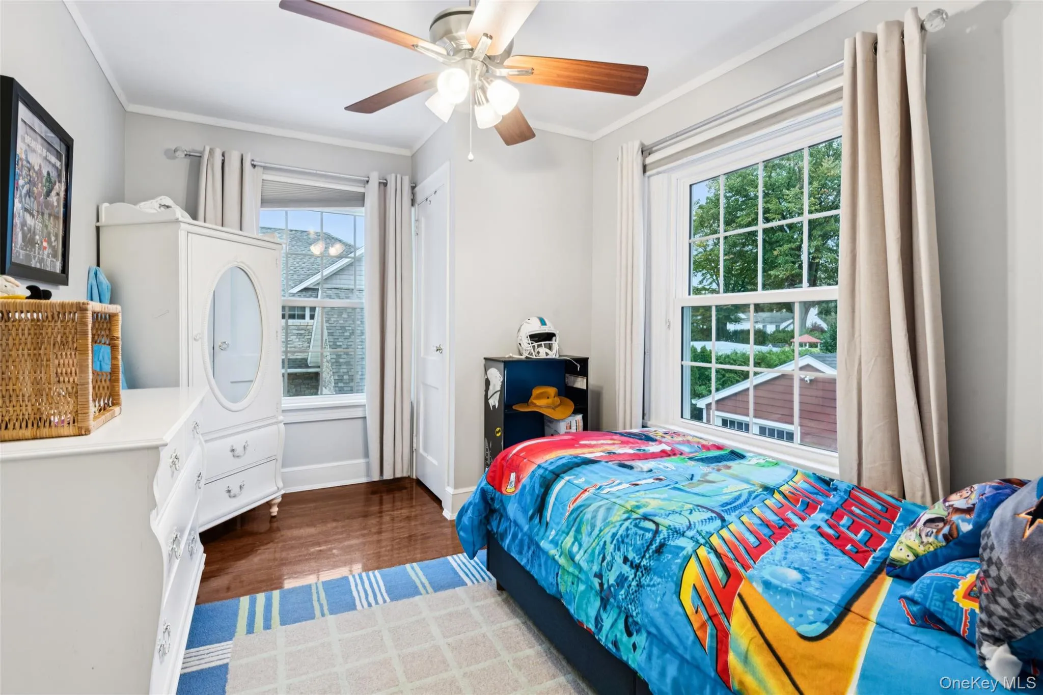 Bedroom featuring ornamental molding, wood finished floors, and a ceiling fan Bedroom featuring ornamental molding, wood finished floors, and a ceiling fan