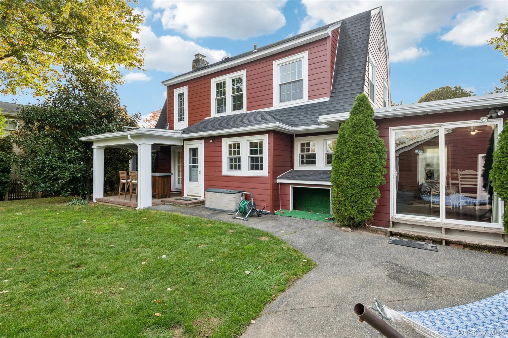 Colonial inspired home featuring a front yard, a shingled roof, a gambrel roof, and a chimney Colonial inspired home featuring a front yard, a shingled roof, a gambrel roof, and a chimney