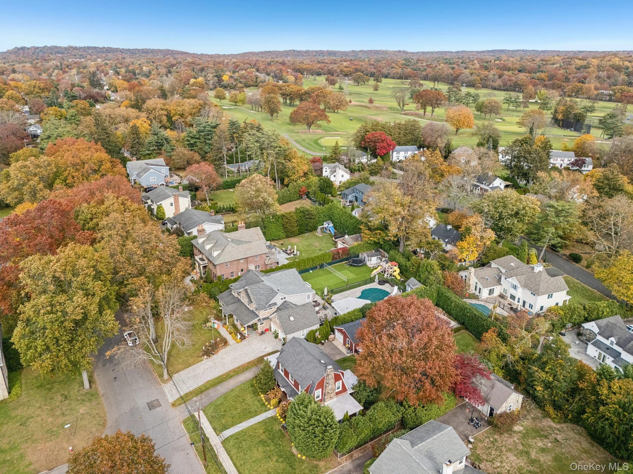 Aerial overview of property's location with nearby suburban area and a golf club Aerial overview of property's location with nearby suburban area and a golf club
