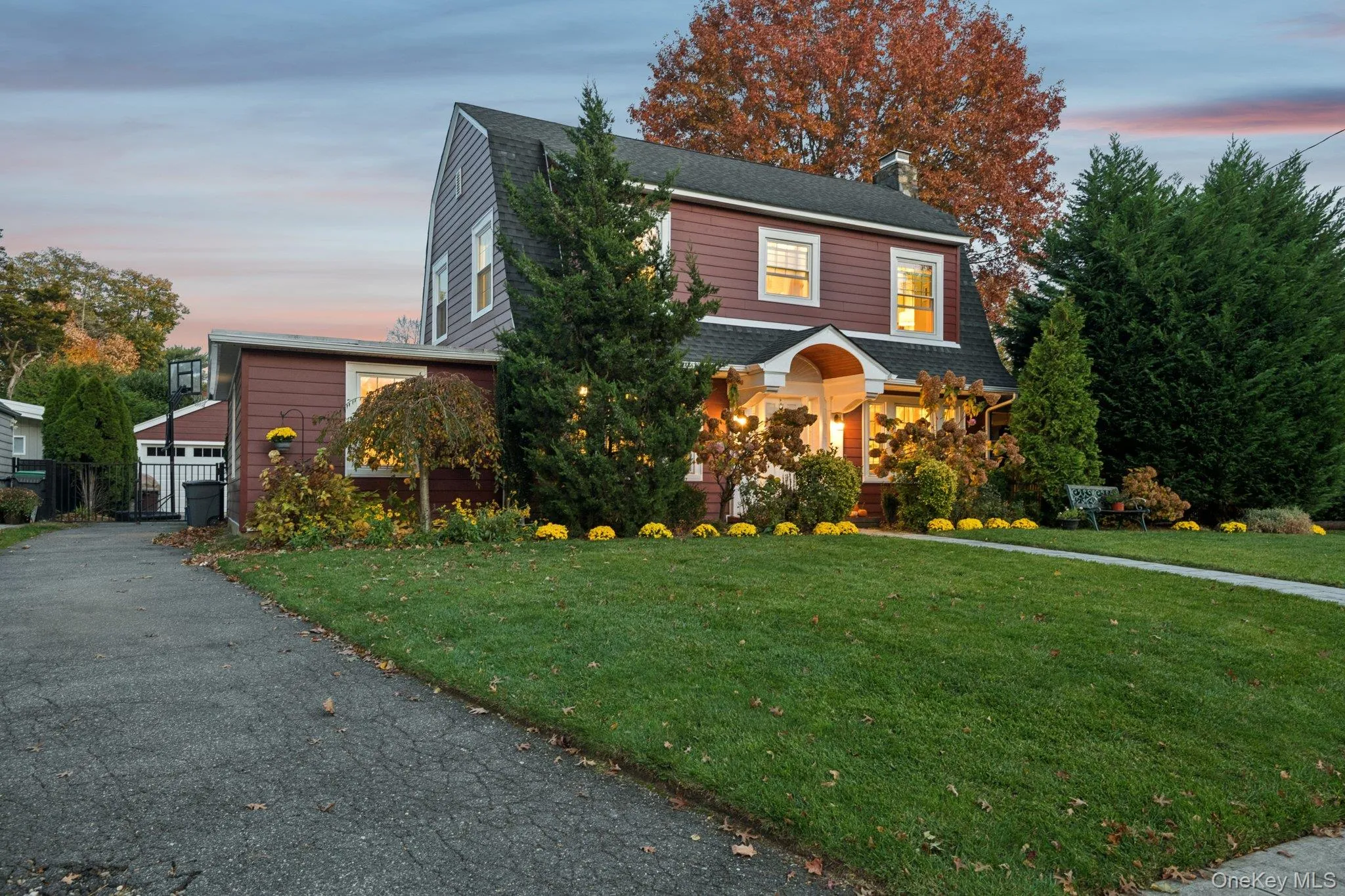 View of front of home with a lawn, a gambrel roof, a shingled roof, and a chimney View of front of home with a lawn, a gambrel roof, a shingled roof, and a chimney