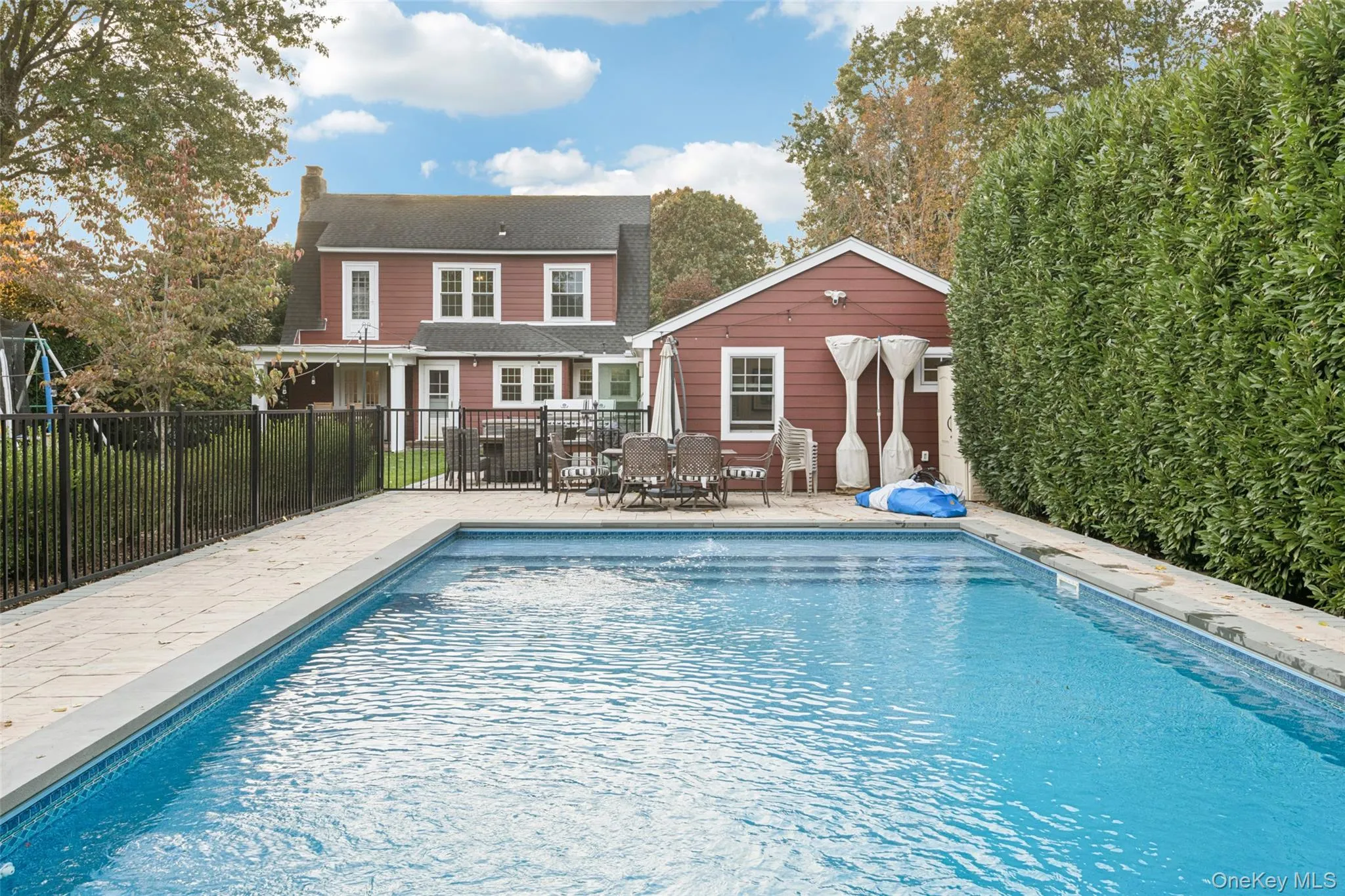 Rear view of house featuring a patio, a chimney, an outbuilding, and outdoor dining area Rear view of house featuring a patio, a chimney, an outbuilding, and outdoor dining area
