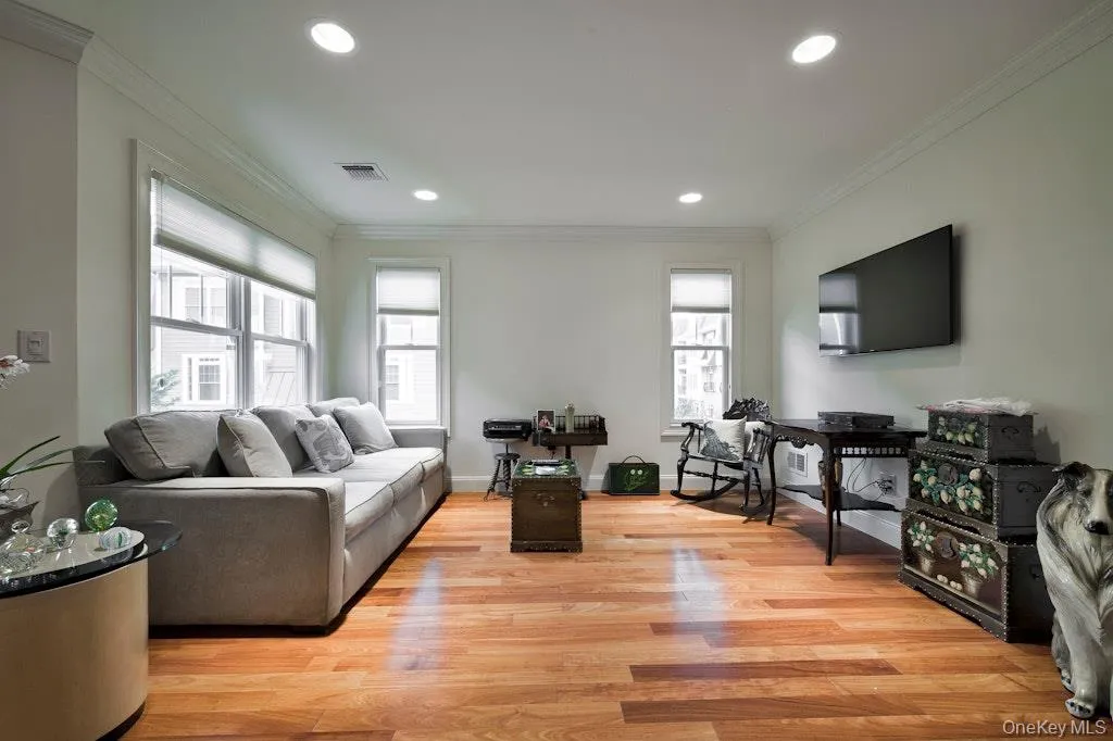 Living room featuring crown molding, light wood finished floors, and recessed lighting Living room featuring crown molding, light wood finished floors, and recessed lighting