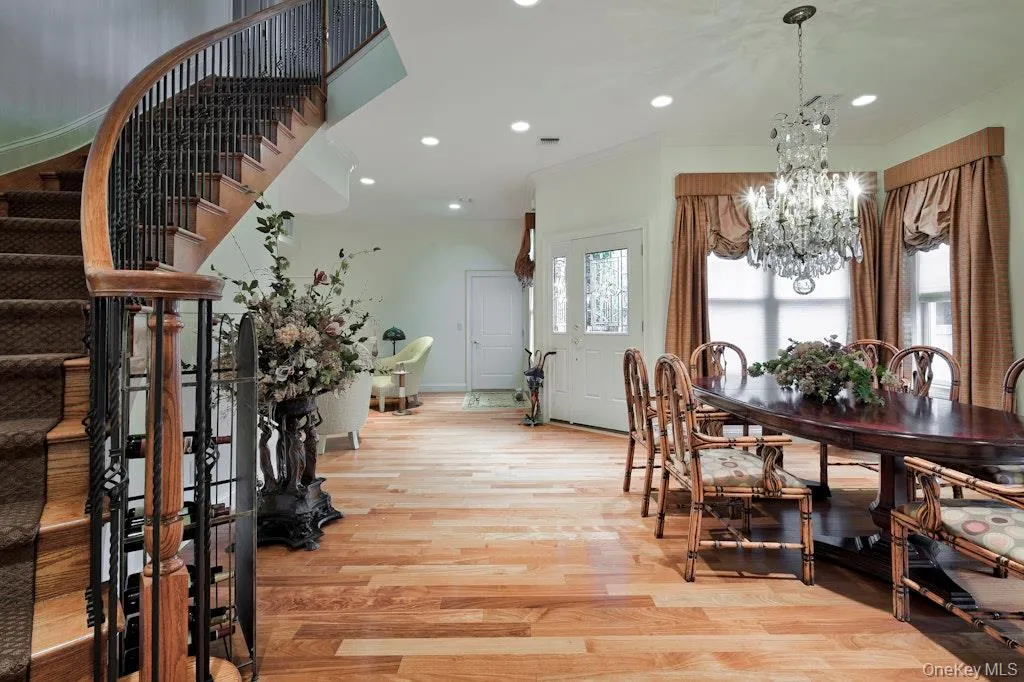 Dining space featuring light wood finished floors, recessed lighting, a chandelier, crown molding, and stairway Dining space featuring light wood finished floors, recessed lighting, a chandelier, crown molding, and stairway