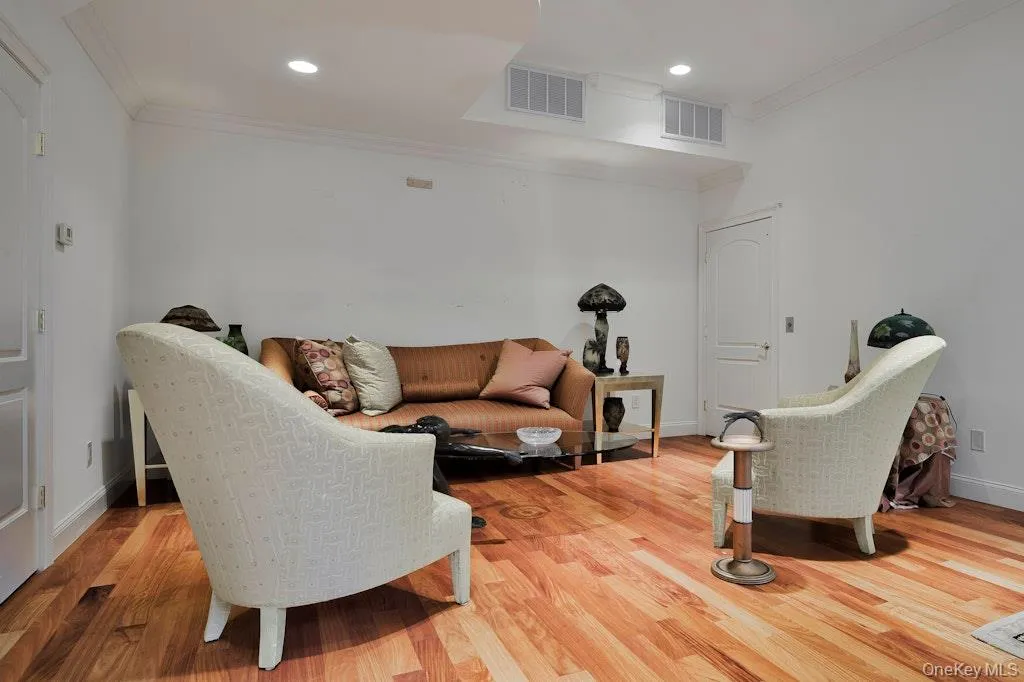 Living room featuring ornamental molding, wood finished floors, and recessed lighting Living room featuring ornamental molding, wood finished floors, and recessed lighting