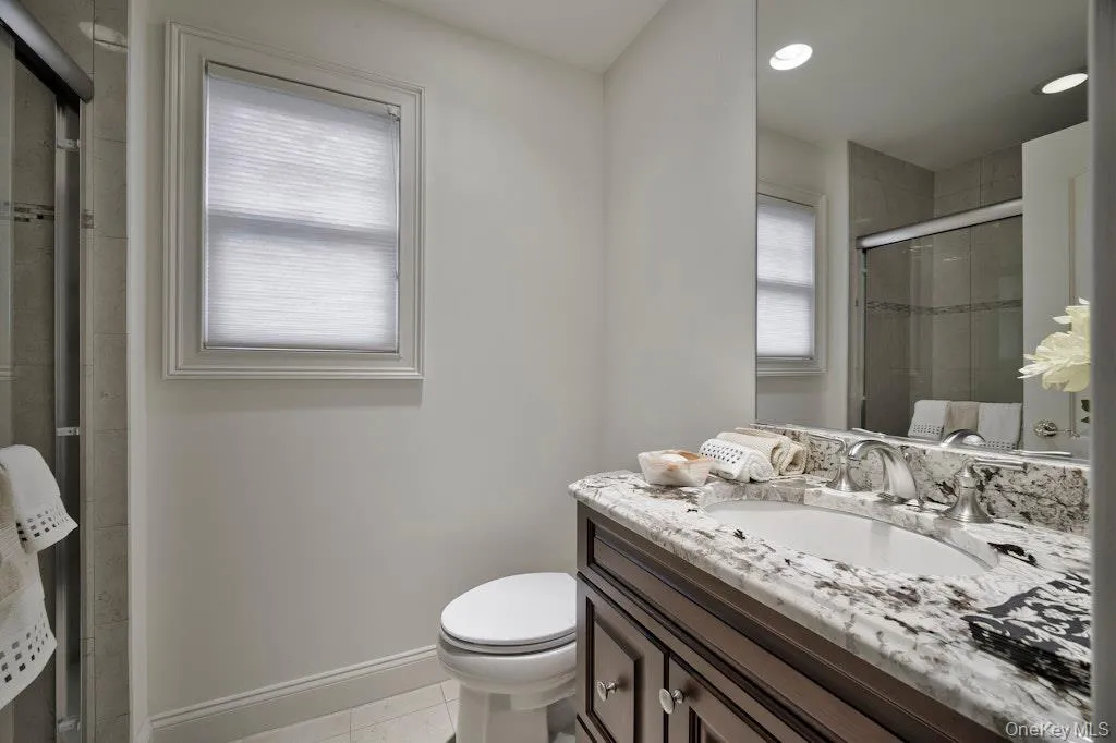 Bathroom with vanity, light tile patterned floors, a stall shower, and recessed lighting Bathroom with vanity, light tile patterned floors, a stall shower, and recessed lighting
