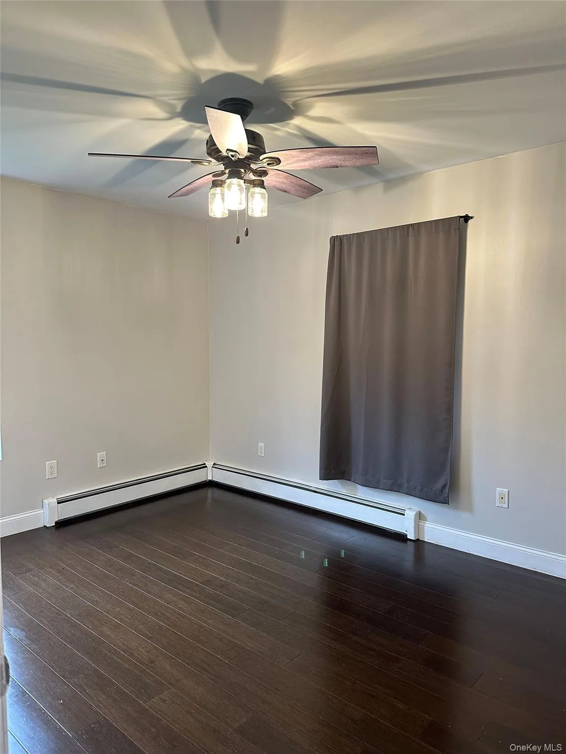 bedroom with dark wood finished floors, a baseboard radiator, and a ceiling fan bedroom with dark wood finished floors, a baseboard radiator, and a ceiling fan