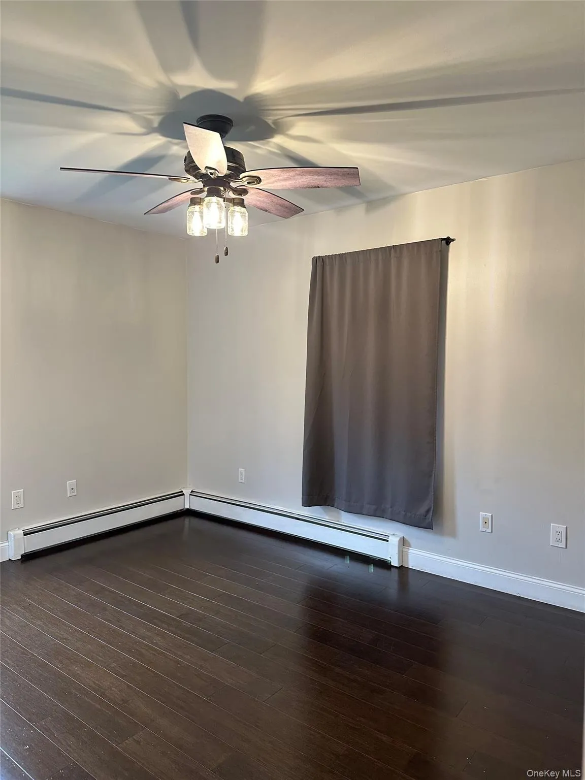 bedroom with dark wood-type flooring, a baseboard heating unit, and ceiling fan bedroom with dark wood-type flooring, a baseboard heating unit, and ceiling fan