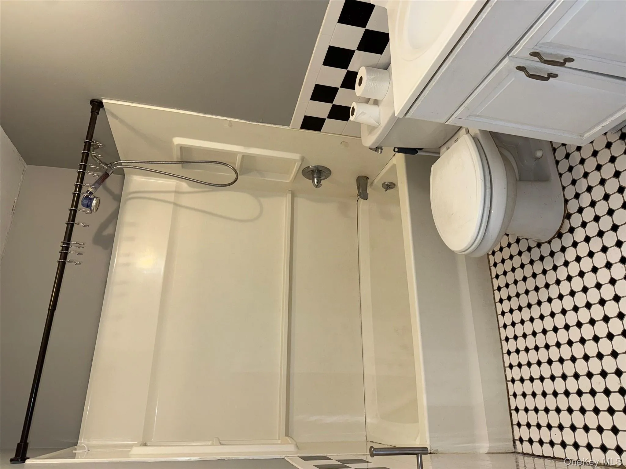 Full bathroom featuring bathing tub / shower combination, vanity, and tile walls Full bathroom featuring bathing tub / shower combination, vanity, and tile walls