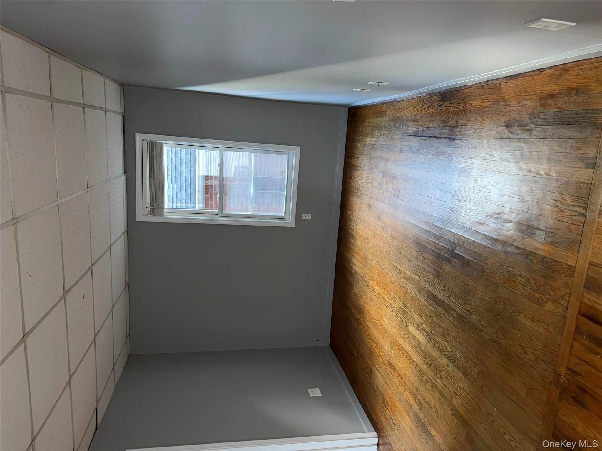 Empty room featuring light wood-style flooring and a drop ceiling Empty room featuring light wood-style flooring and a drop ceiling