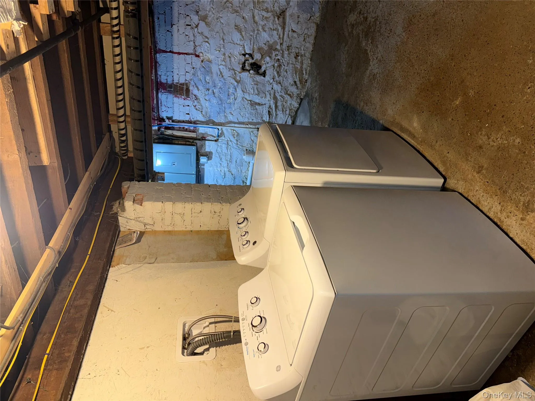 Washroom with electric panel, concrete flooring, and separate washer and dryer Washroom with electric panel, concrete flooring, and separate washer and dryer