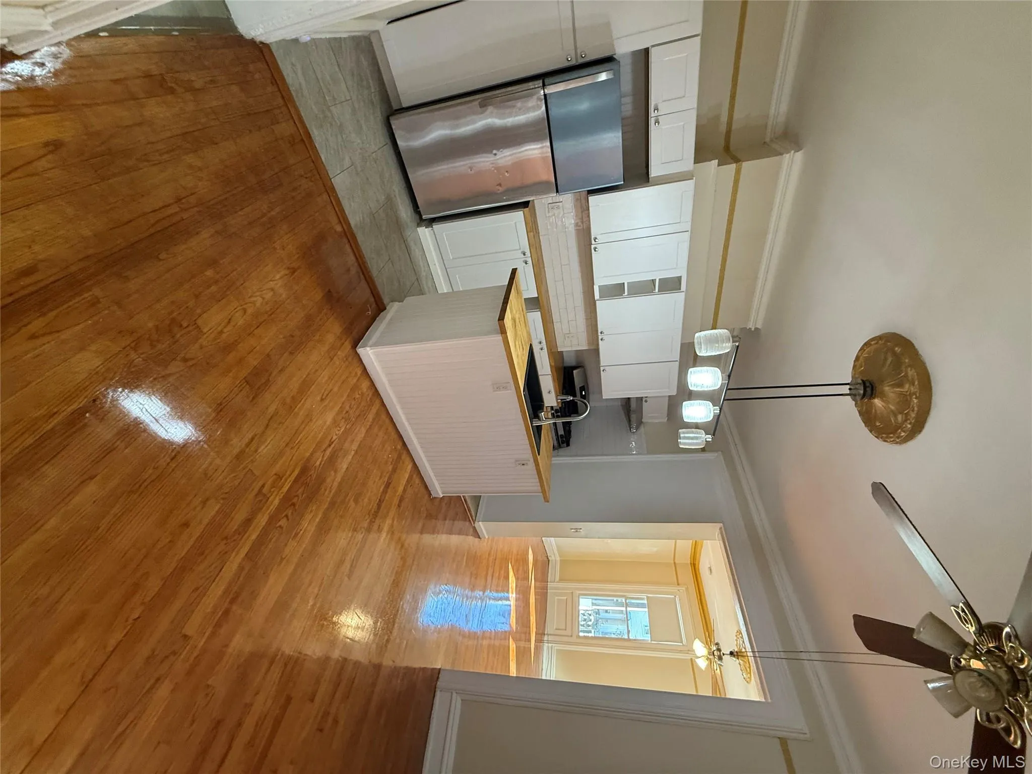 Kitchen with ornamental molding, tasteful backsplash, decorative light fixtures, light wood-style floors, and fridge Kitchen with ornamental molding, tasteful backsplash, decorative light fixtures, light wood-style floors, and fridge