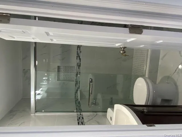 Full bathroom featuring vanity, marble finish flooring, and a marble finish shower Full bathroom featuring vanity, marble finish flooring, and a marble finish shower