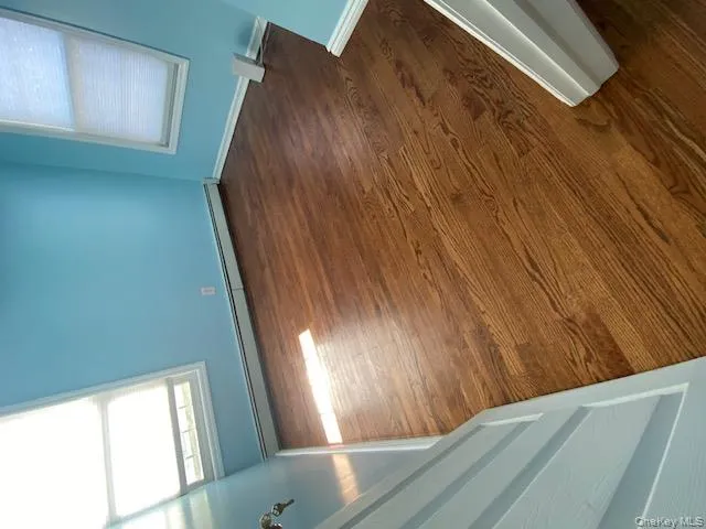 Empty room with dark wood finished floors and a baseboard heating unit Empty room with dark wood finished floors and a baseboard heating unit