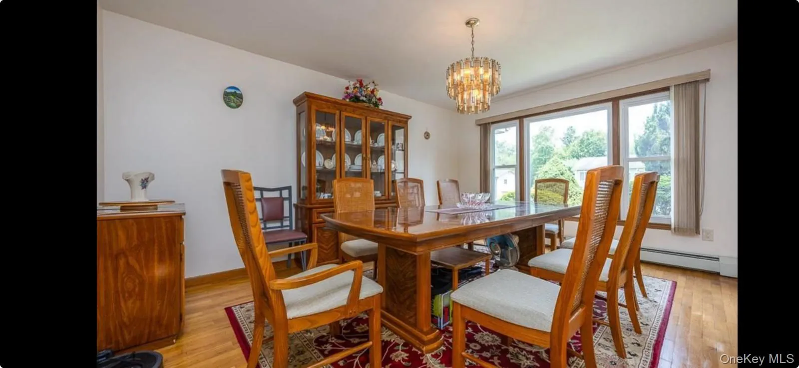 Dining room featuring light wood-type flooring, a chandelier, and baseboard heating Dining room featuring light wood-type flooring, a chandelier, and baseboard heating