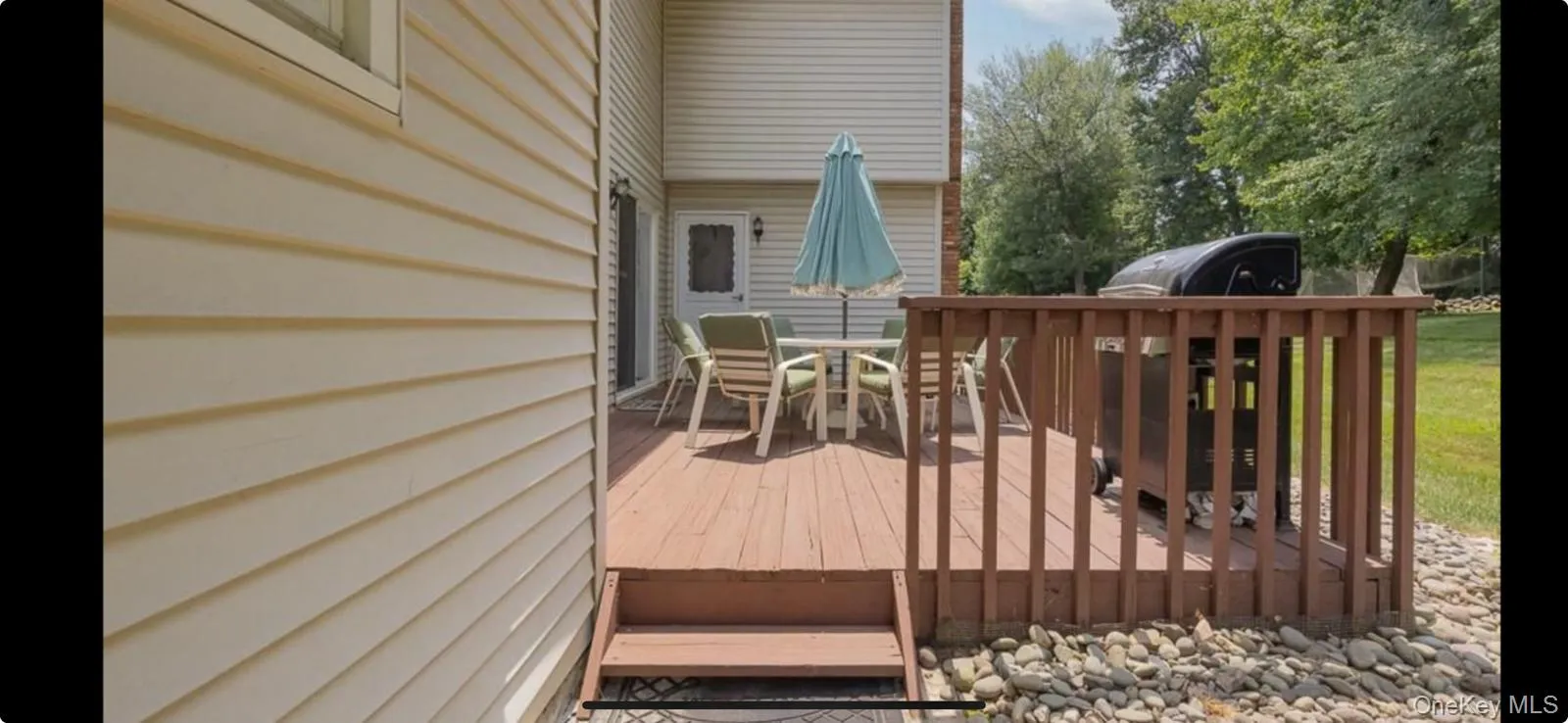 Deck with a grill, outdoor dining area, and a lawn Deck with a grill, outdoor dining area, and a lawn