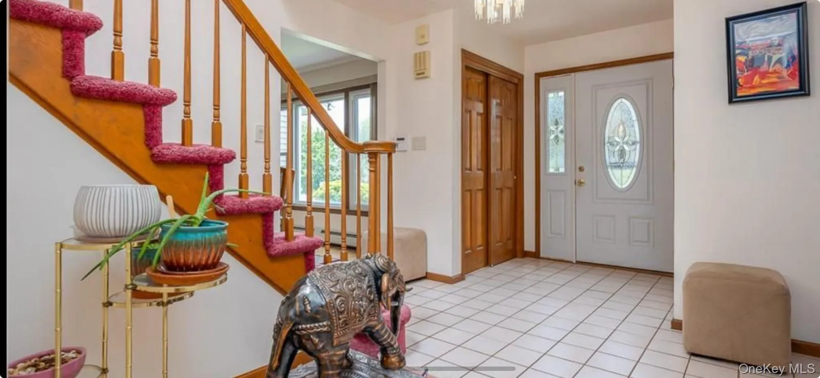 Tiled foyer with plenty of natural light, stairway, and a chandelier Tiled foyer with plenty of natural light, stairway, and a chandelier