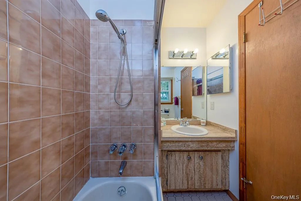 Bathroom featuring bathtub / shower combination and vanity Bathroom featuring bathtub / shower combination and vanity