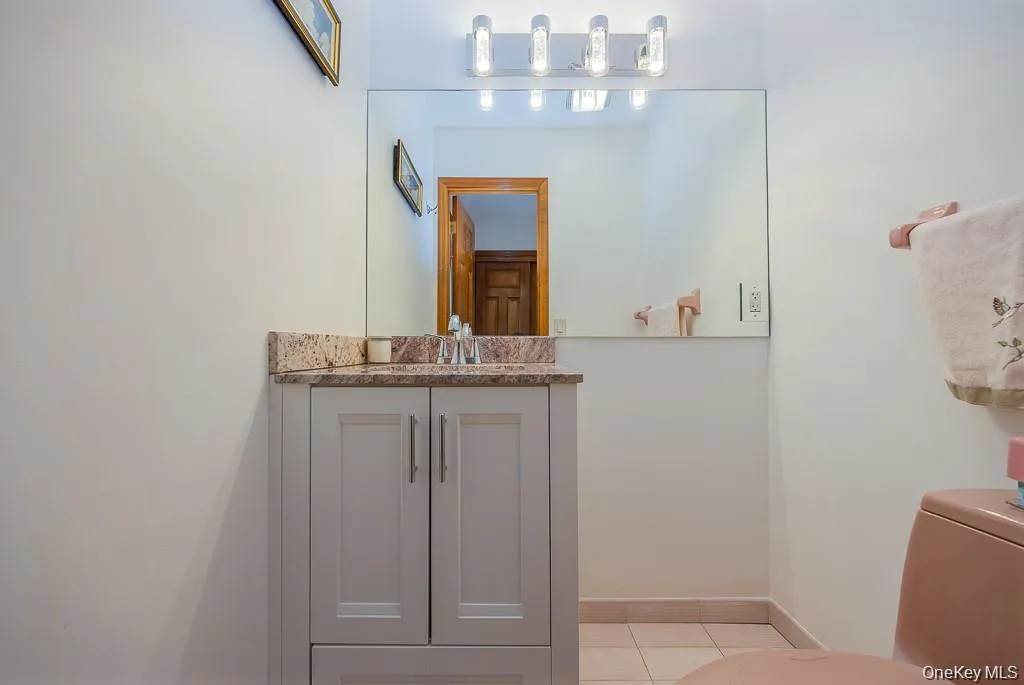 Half bathroom with vanity and light tile patterned floors Half bathroom with vanity and light tile patterned floors
