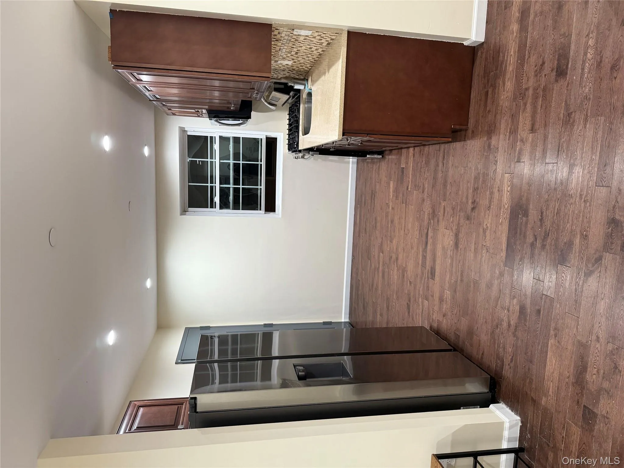 Kitchen featuring refrigerator, tasteful backsplash, dark wood-type flooring, light stone countertops, and recessed lighting Kitchen featuring refrigerator, tasteful backsplash, dark wood-type flooring, light stone countertops, and recessed lighting