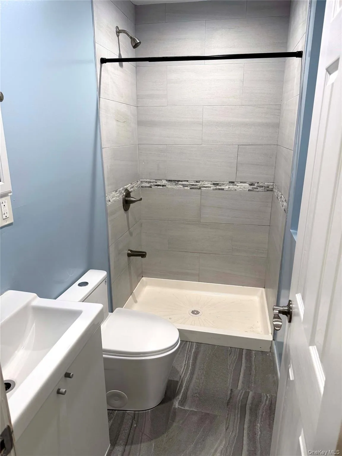 Bathroom featuring a shower stall and vanity Bathroom featuring a shower stall and vanity