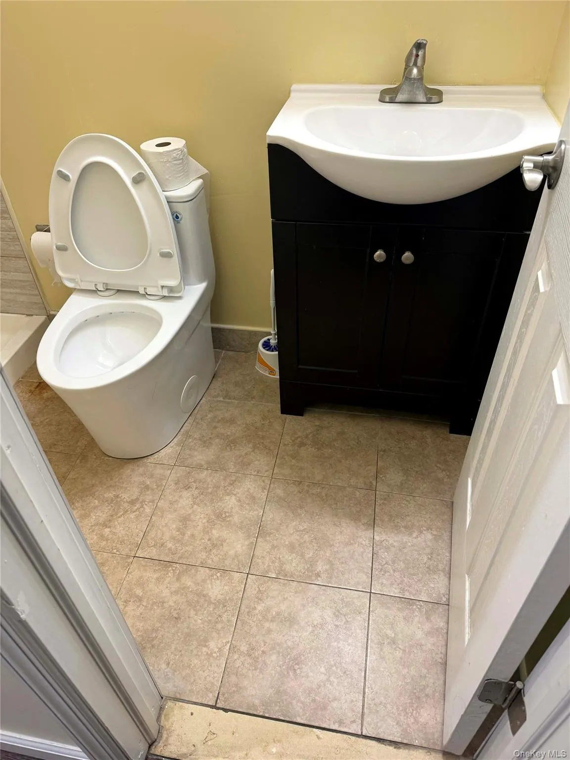 Half bath featuring vanity and light tile patterned floors Half bath featuring vanity and light tile patterned floors