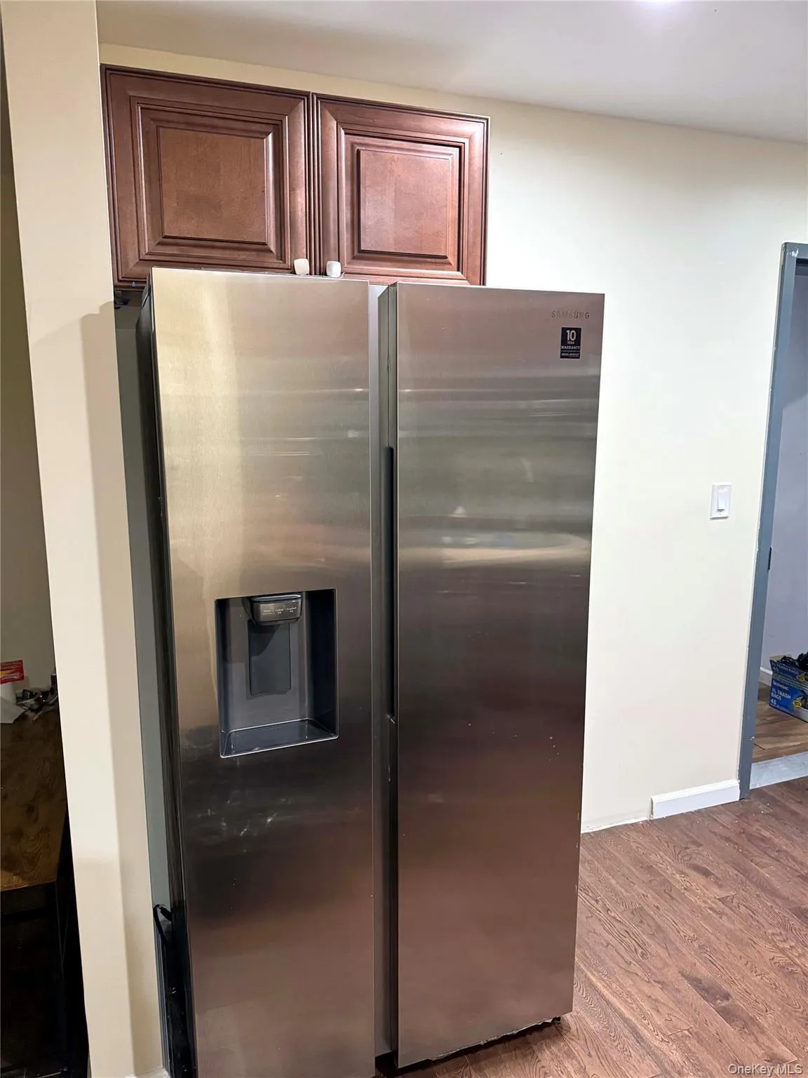 Kitchen featuring stainless steel fridge and dark wood-style flooring Kitchen featuring stainless steel fridge and dark wood-style flooring