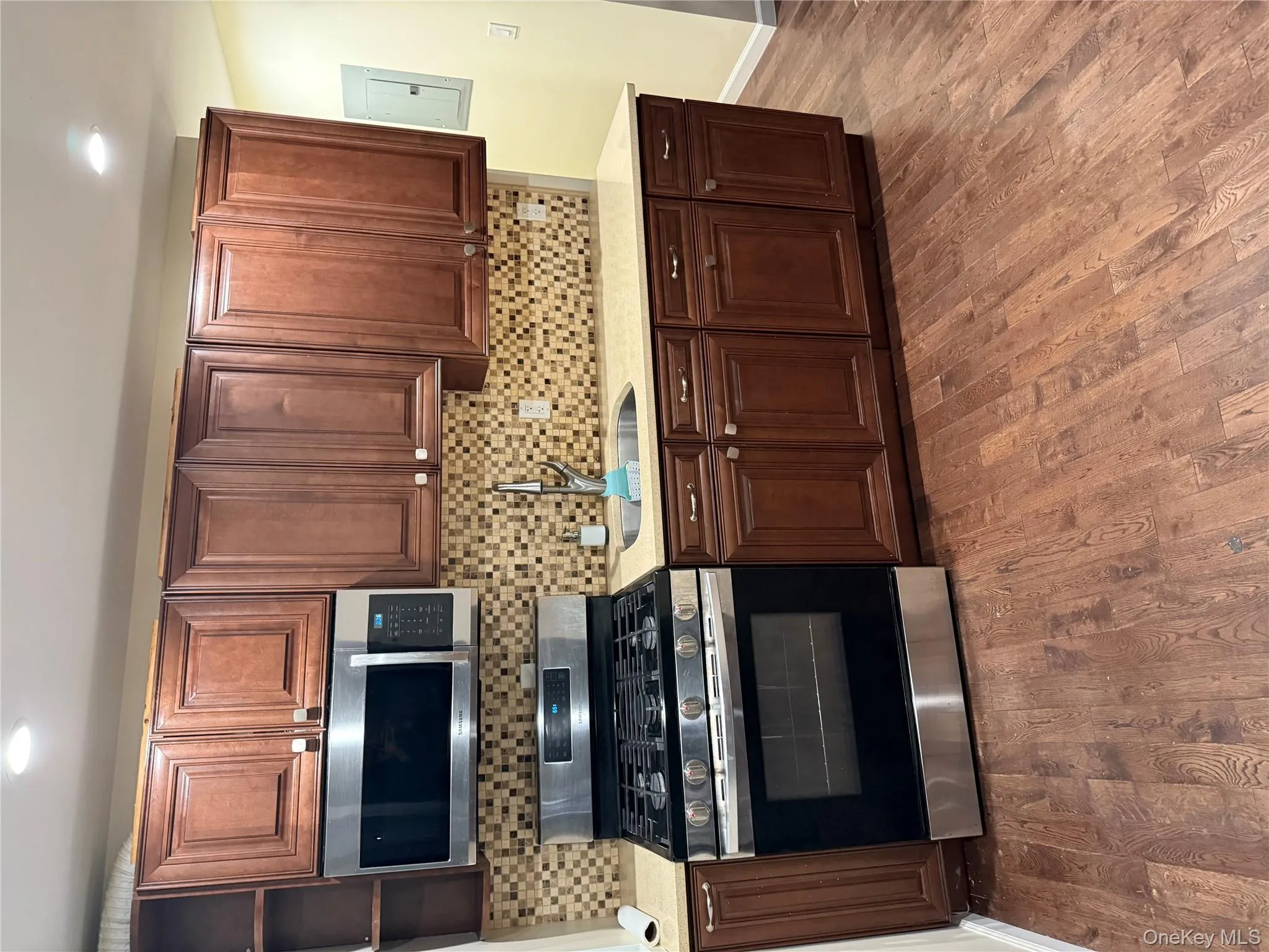 Kitchen featuring stainless steel range, backsplash, dark wood-type flooring, and recessed lighting Kitchen featuring stainless steel range, backsplash, dark wood-type flooring, and recessed lighting