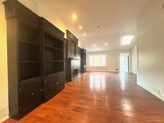 Unfurnished living room with vaulted ceiling and light wood-style flooring Unfurnished living room with vaulted ceiling and light wood-style flooring