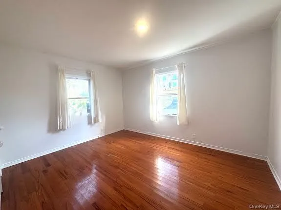 Empty room featuring wood finished floors and baseboards Empty room featuring wood finished floors and baseboards