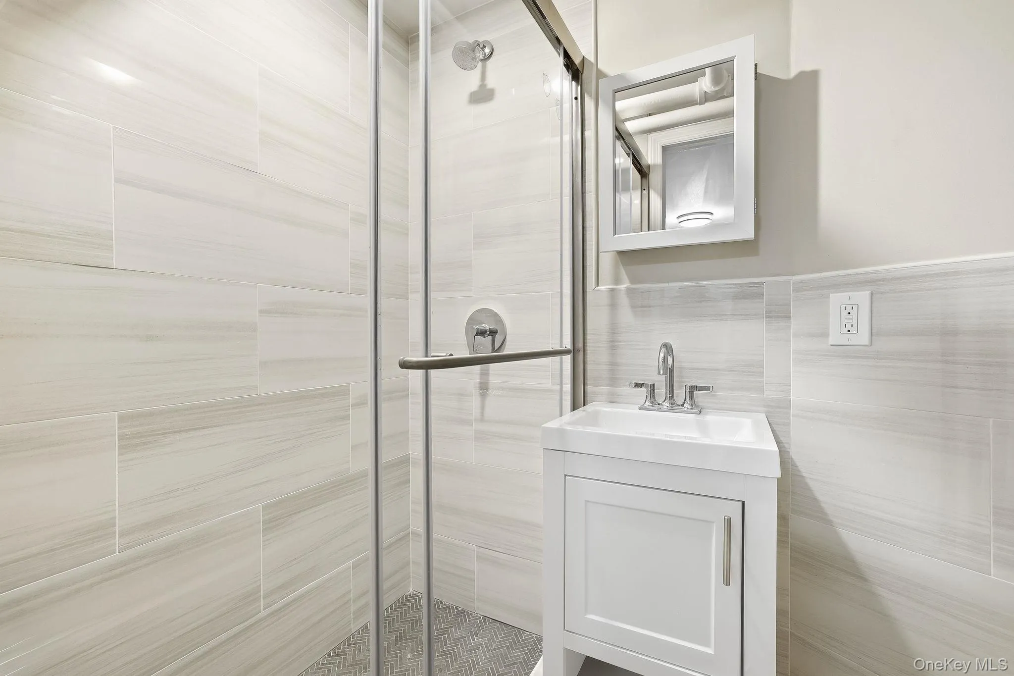 This bathroom has a shower stall with a sliding glass door This bathroom has a shower stall with a sliding glass door