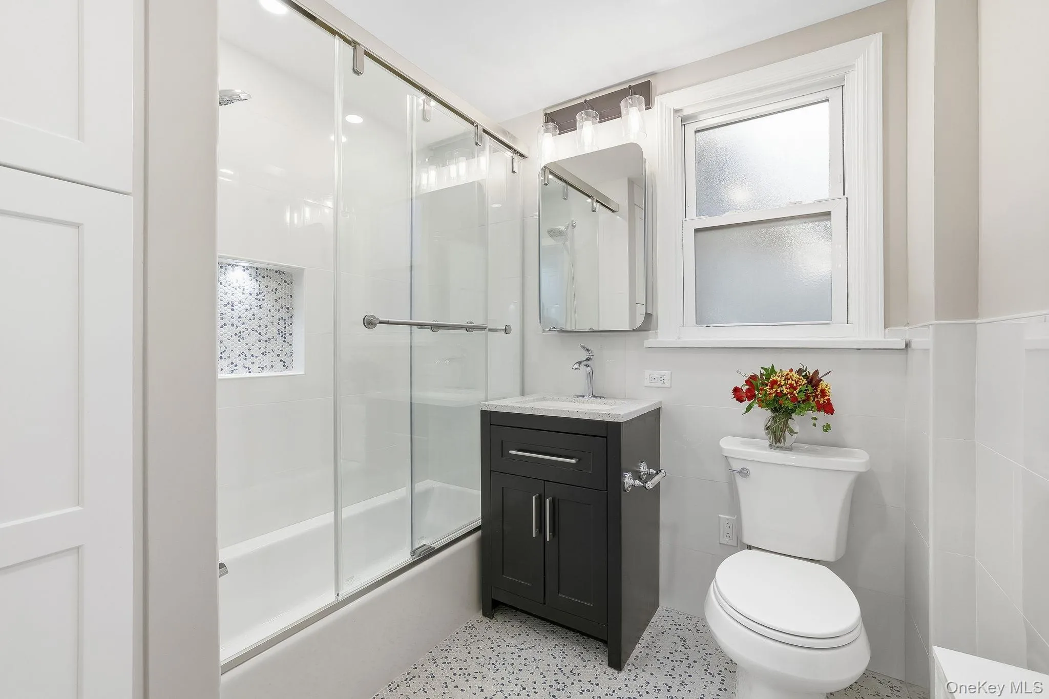 This totally renovated bathroom has a linen closet within and presents beautifully with new tile, lighting and fixtures This totally renovated bathroom has a linen closet within and presents beautifully with new tile, lighting and fixtures