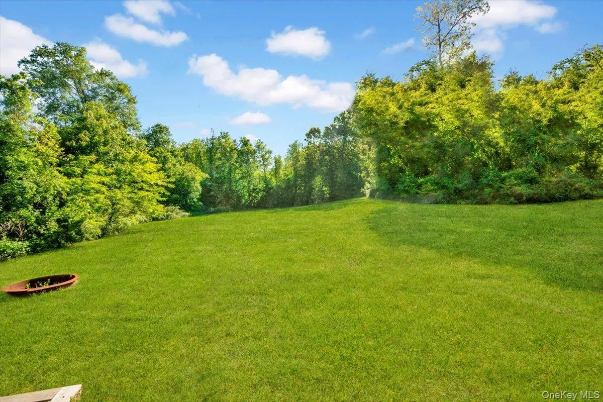View of grassy yard with a fire pit View of grassy yard with a fire pit