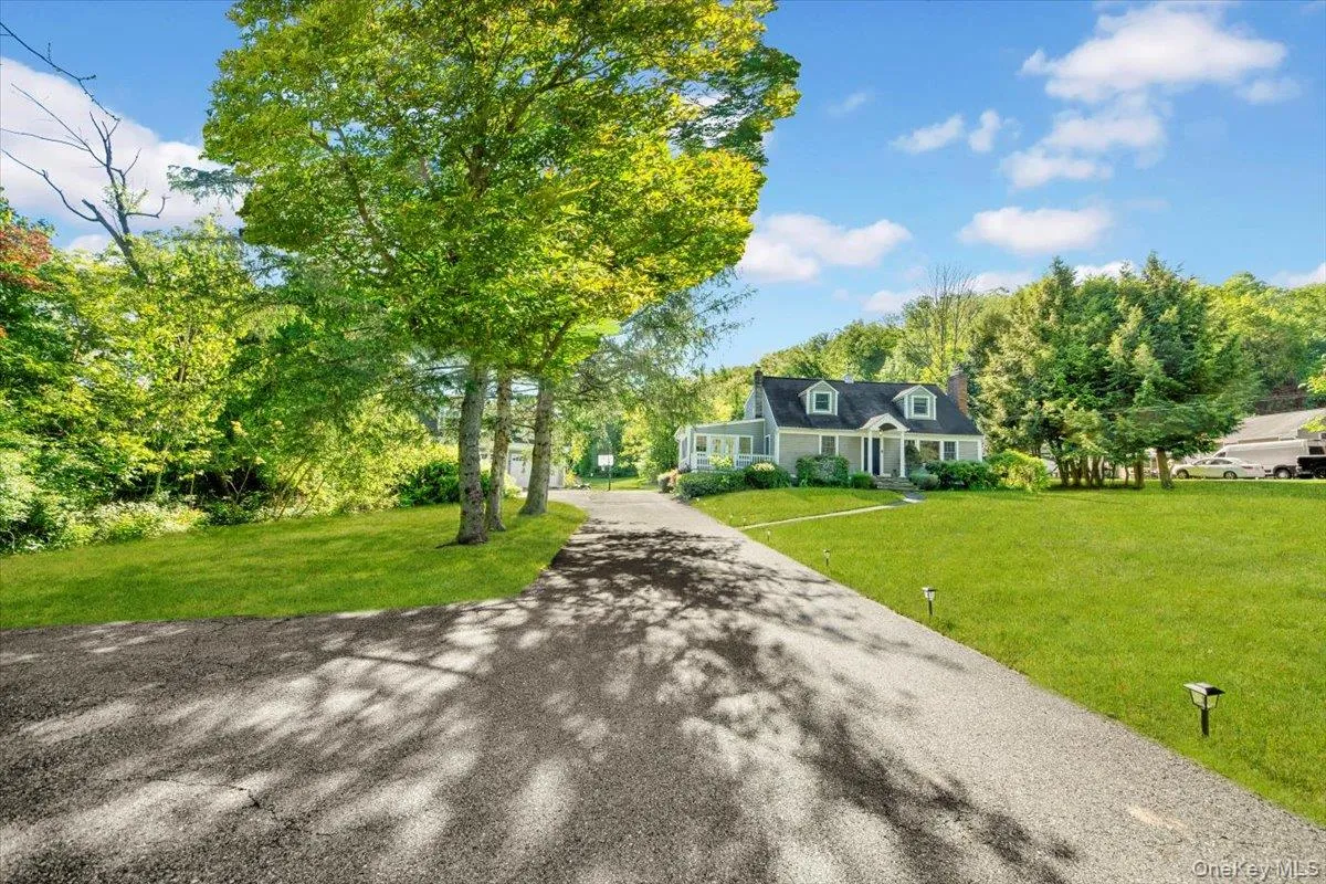 Cape cod home with a front lawn and driveway Cape cod home with a front lawn and driveway