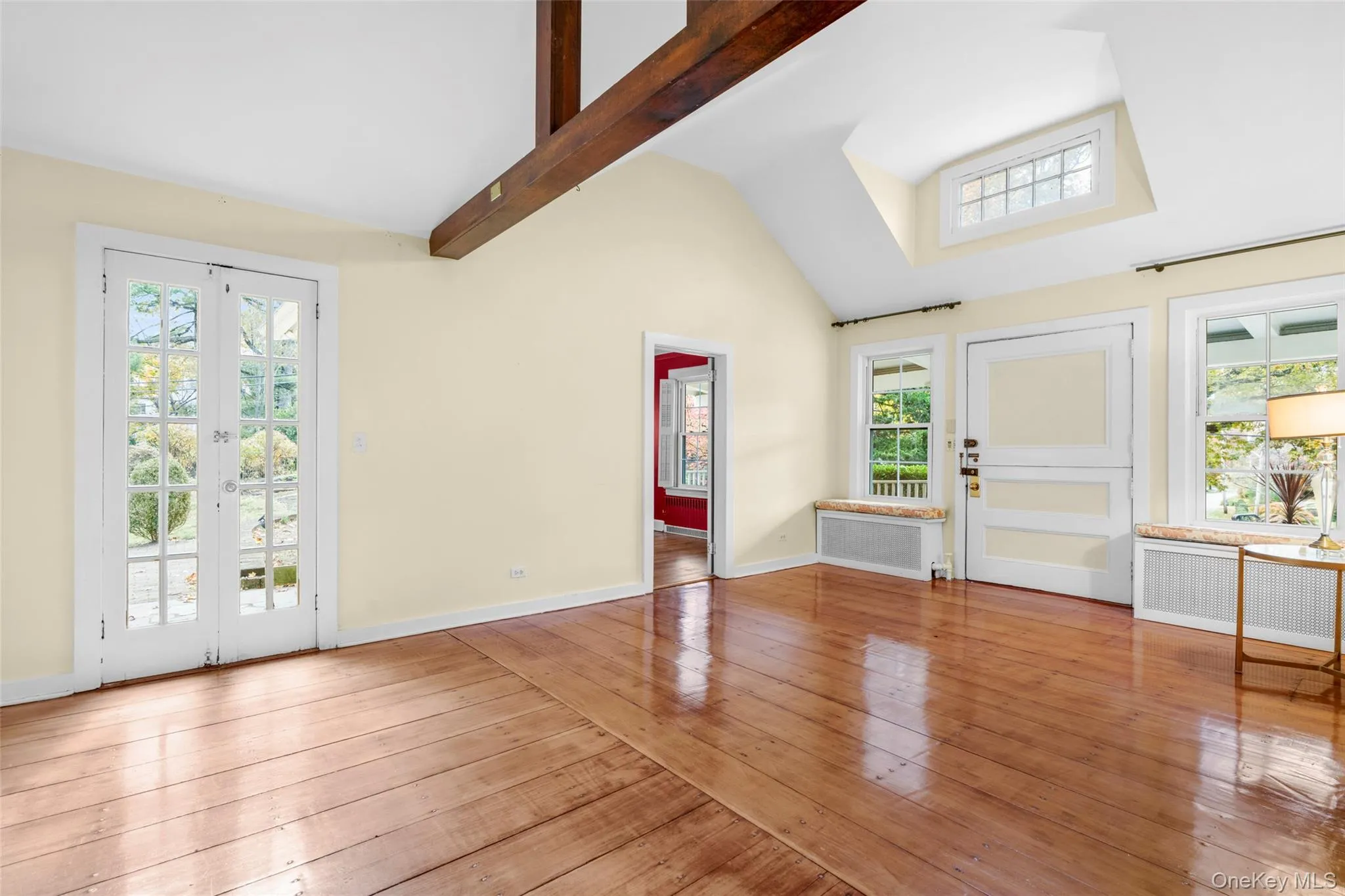 Entryway with radiator heating unit, hardwood / wood-style flooring, beam ceiling, high vaulted ceiling, and french doors Entryway with radiator heating unit, hardwood / wood-style flooring, beam ceiling, high vaulted ceiling, and french doors