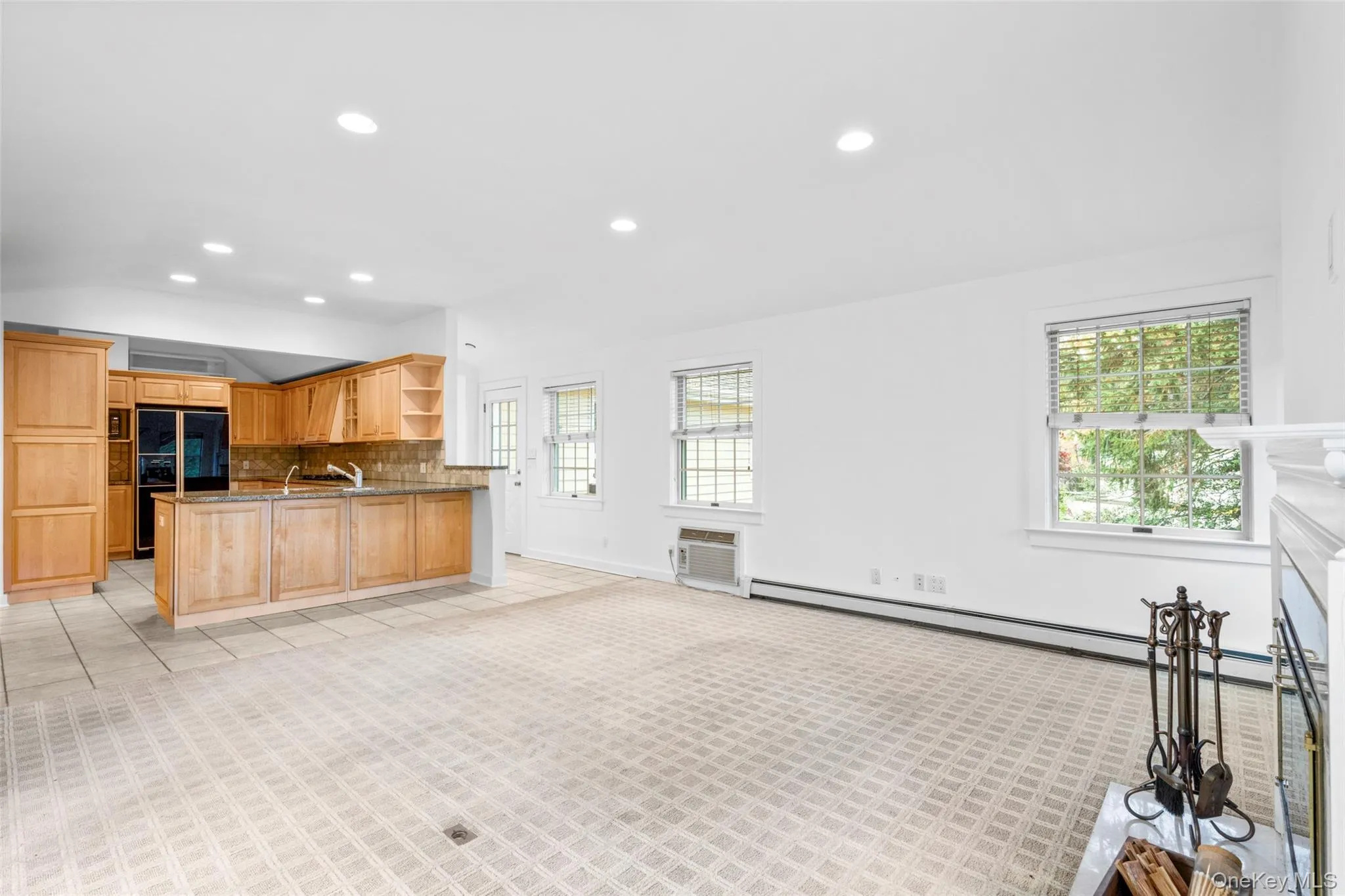 Kitchen featuring a peninsula, recessed lighting, decorative backsplash, open shelves, and high end black refrigerator Kitchen featuring a peninsula, recessed lighting, decorative backsplash, open shelves, and high end black refrigerator