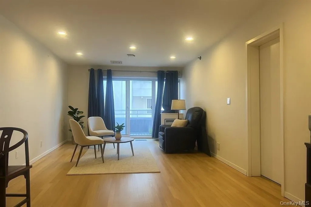 Living area with elevator, light wood-style flooring, and recessed lighting Living area with elevator, light wood-style flooring, and recessed lighting