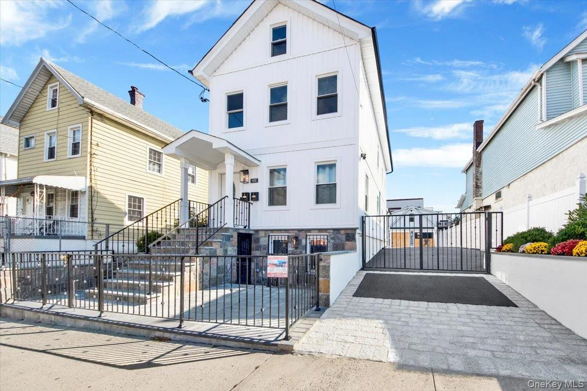View of front of property with a gate, a fenced front yard, a residential view, and board and batten siding View of front of property with a gate, a fenced front yard, a residential view, and board and batten siding