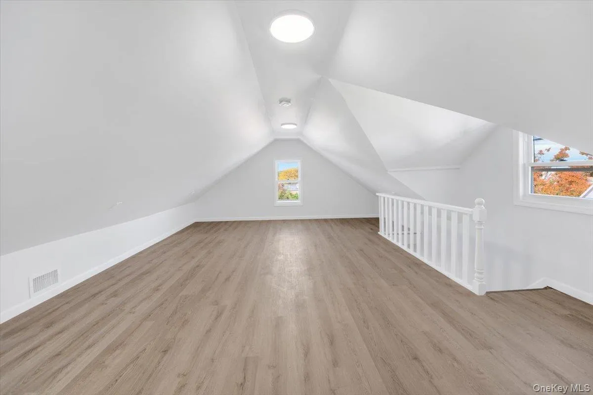 Bonus room featuring vaulted ceiling and light wood-type flooring Bonus room featuring vaulted ceiling and light wood-type flooring