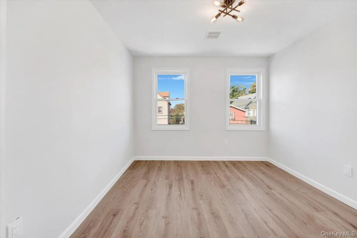Empty room with light wood finished floors and baseboards Empty room with light wood finished floors and baseboards