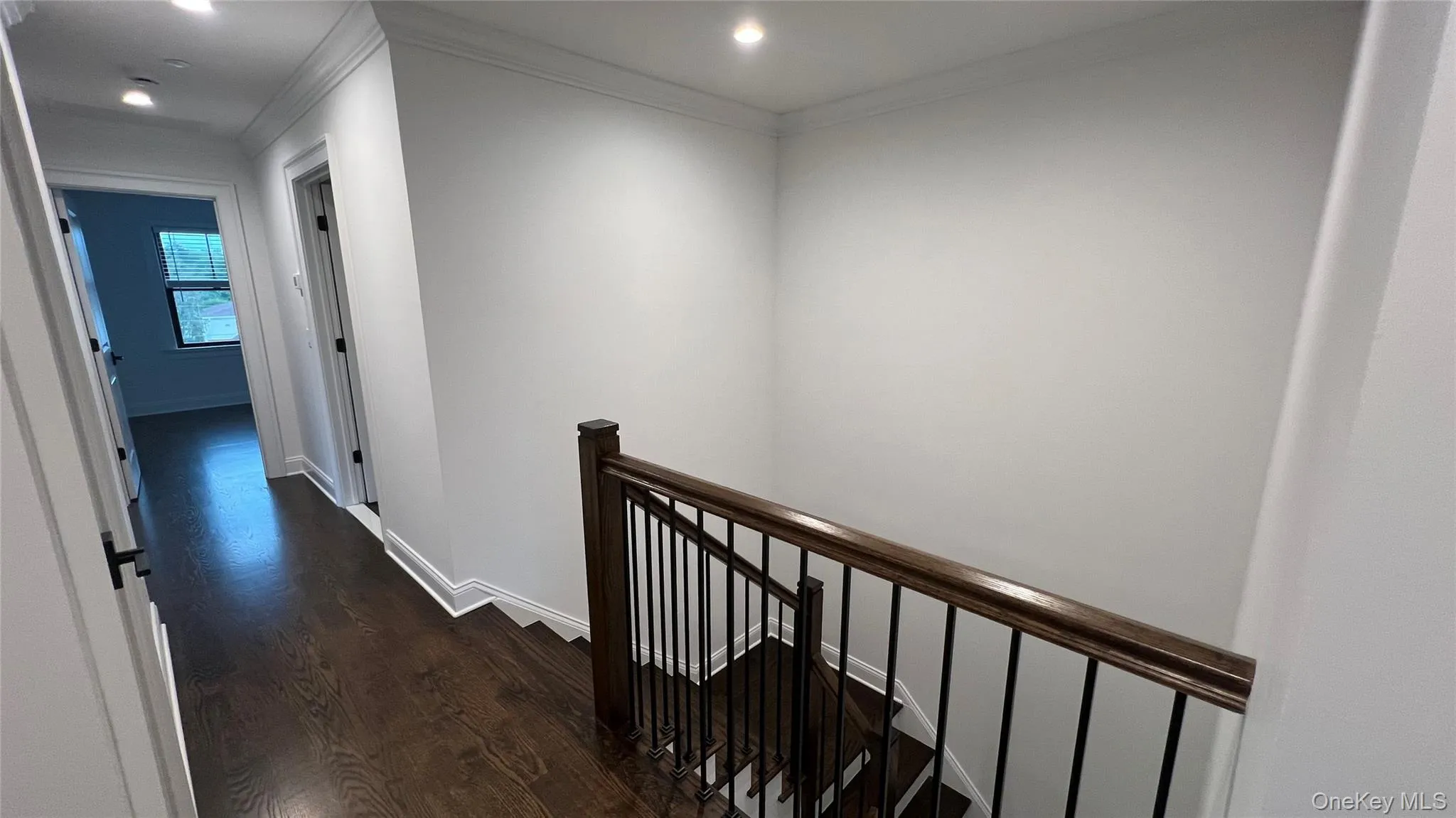 Corridor featuring an upstairs landing, dark wood-style flooring, ornamental molding, and recessed lighting Corridor featuring an upstairs landing, dark wood-style flooring, ornamental molding, and recessed lighting